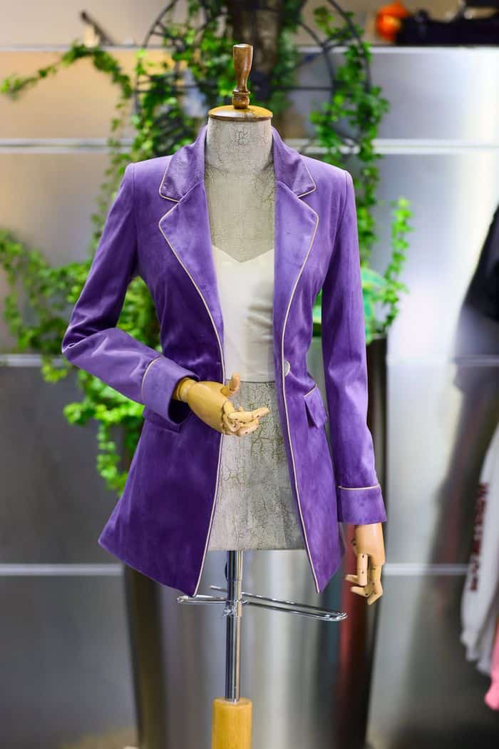 Elegant purple velvet jacket displayed on a mannequin in a stylish boutique setting.